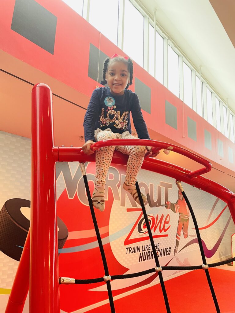 Little girl sitting on jungle gym