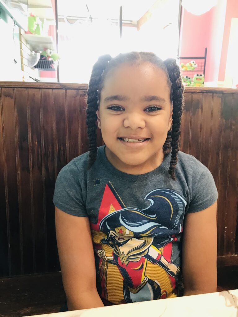 Smiling little girl sitting in a restaurant booth
